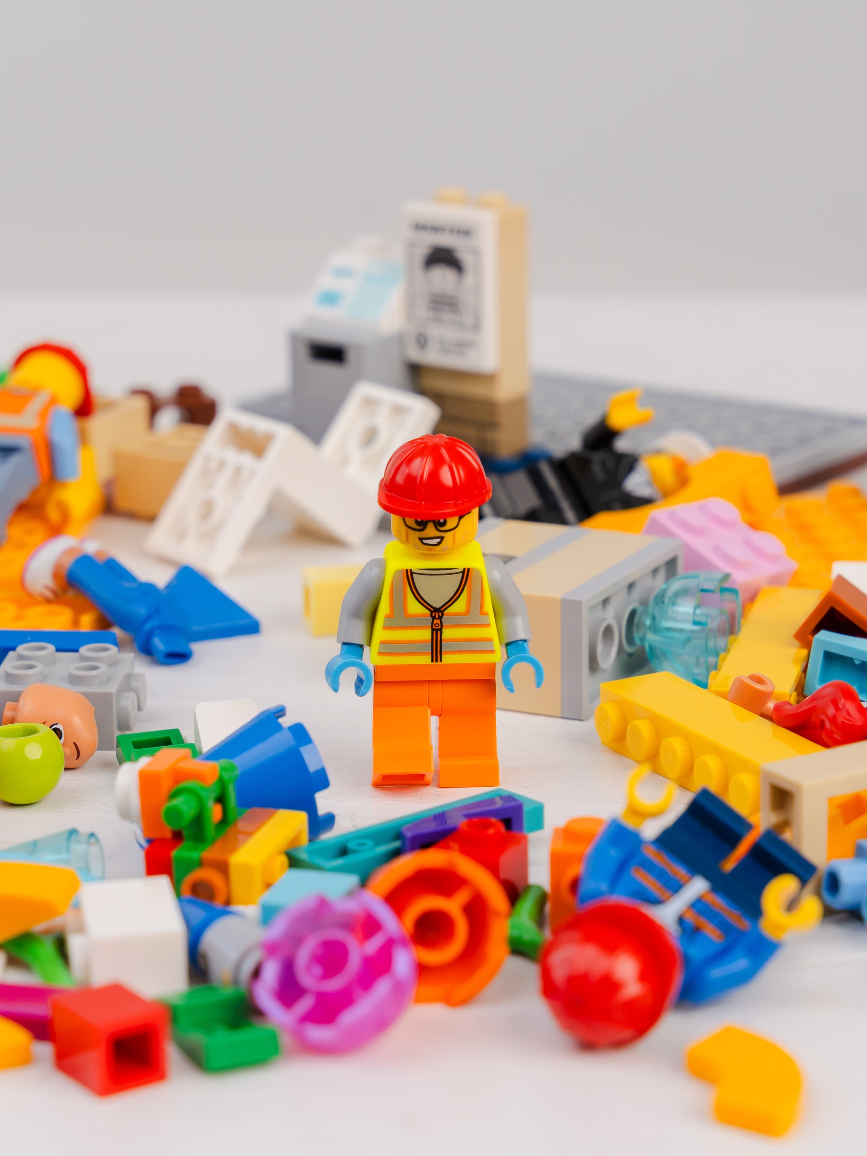 LEGO construction figure surrounded by colourful pieces