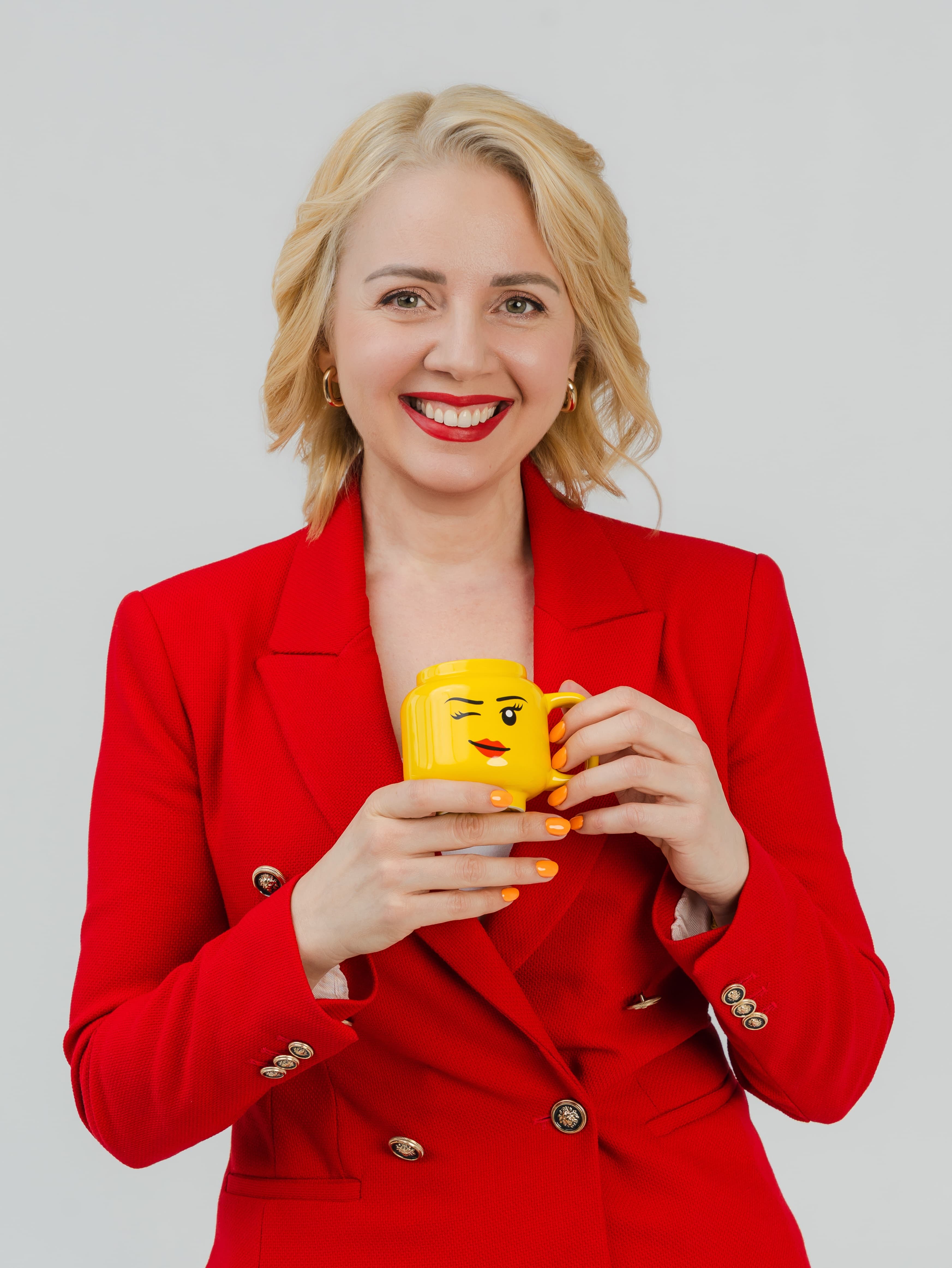 Maria smiling and holding a yellow LEGO-inspired cup